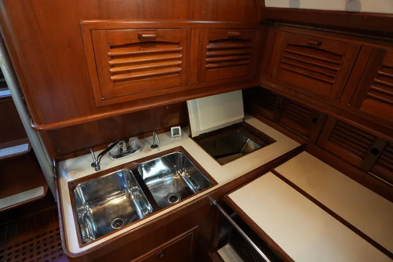 Slide: The Image of 1985 Ta Chiao 38 yacht kitchen with wooden cabinets and dual stainless steel sinks. - 21