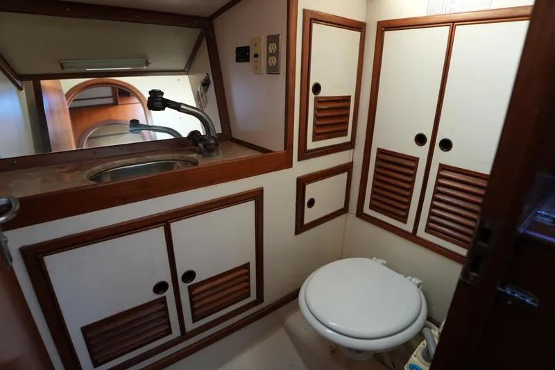 Slide: The Image of 1985 Ta Chiao 38 yacht bathroom with sink, toilet, and wooden cabinets. - 25