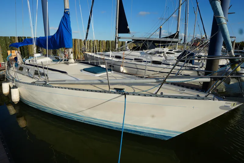 Slide: The Image of 1985 Ta Chiao 38 sailboat docked, featuring blue sail cover and sleek design. - 3