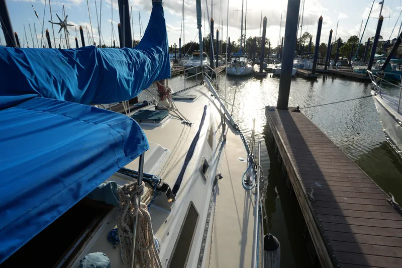Slide: The Image of 1985 Ta Chiao 38 sailboat docked at marina, sunlit deck and blue covers. - 7