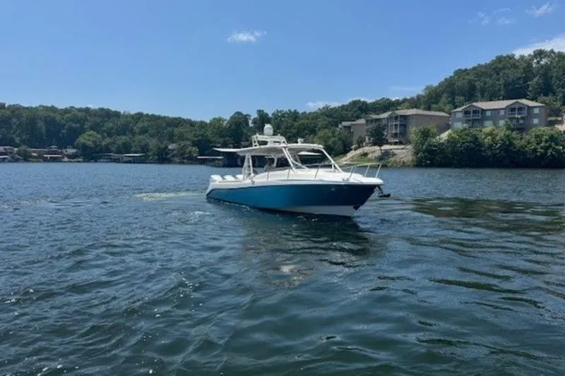 Slide: The Image of 2016 Everglades 360LXC boat on a scenic lake with wooded shoreline. - 18