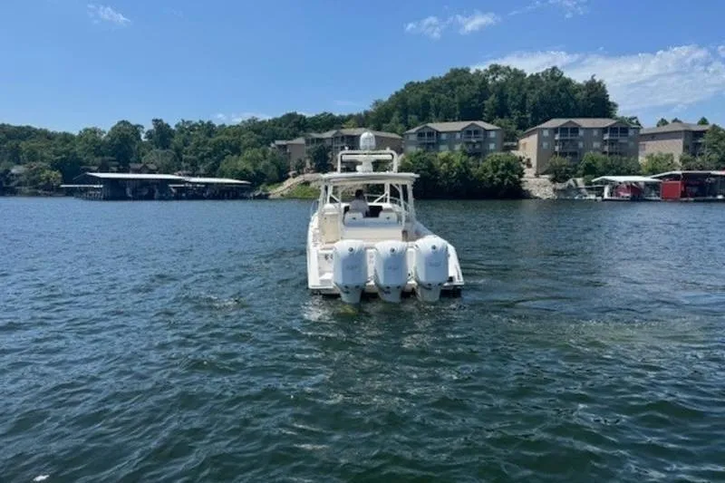 Slide: The Image of 2016 Everglades 360LXC boat on a lake with scenic shoreline and buildings. - 23