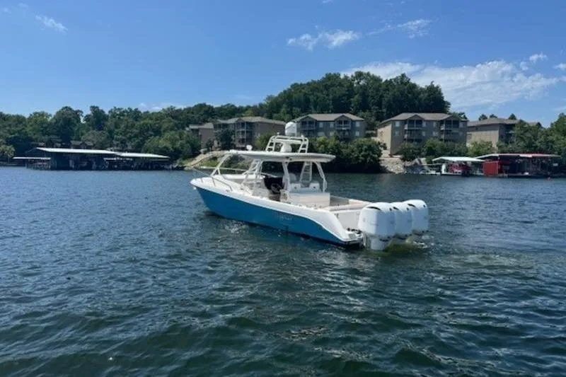 Slide: The Image of 2016 Everglades 360LXC boat on a scenic lake with waterfront buildings. - 26