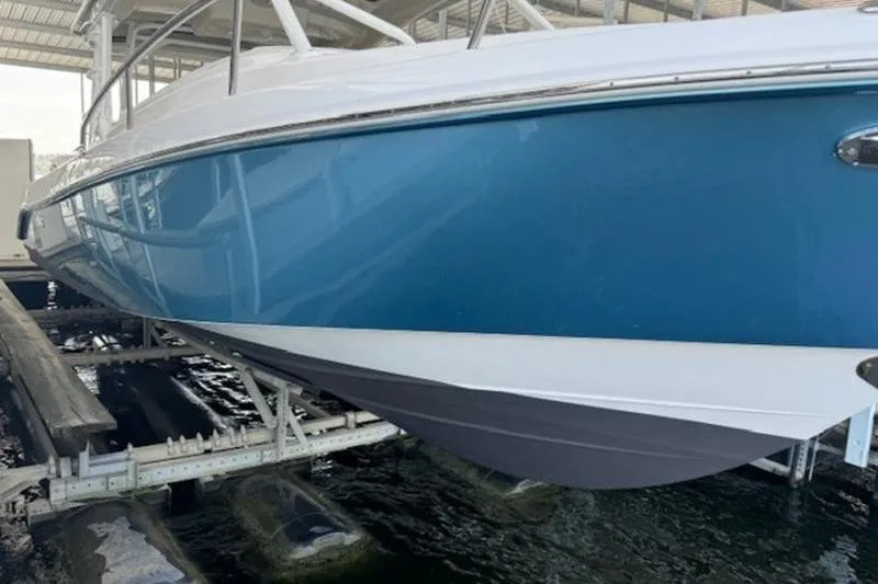 Slide: The Image of 2016 Everglades 360LXC boat in dry dock, blue hull, side view. - 33