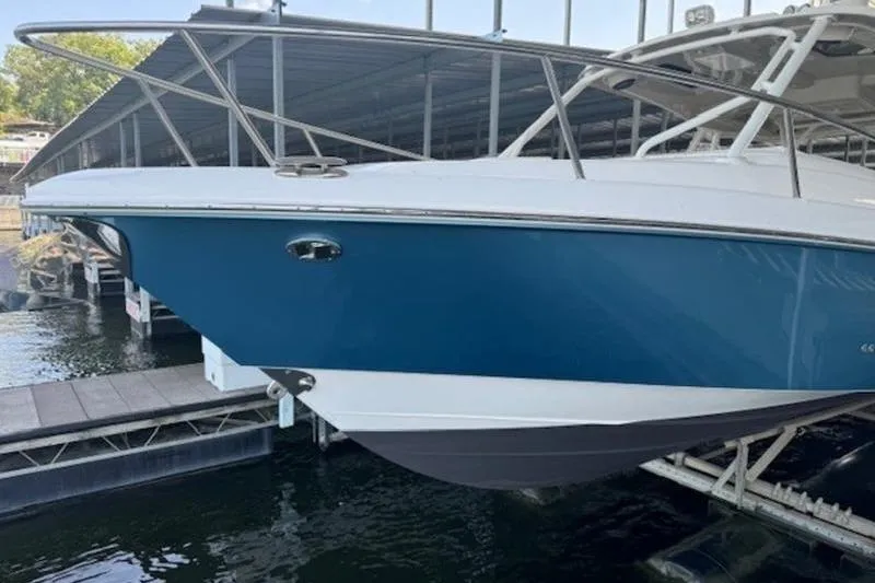 Slide: The Image of 2016 Everglades 360LXC boat docked in marina, blue and white hull. - 37