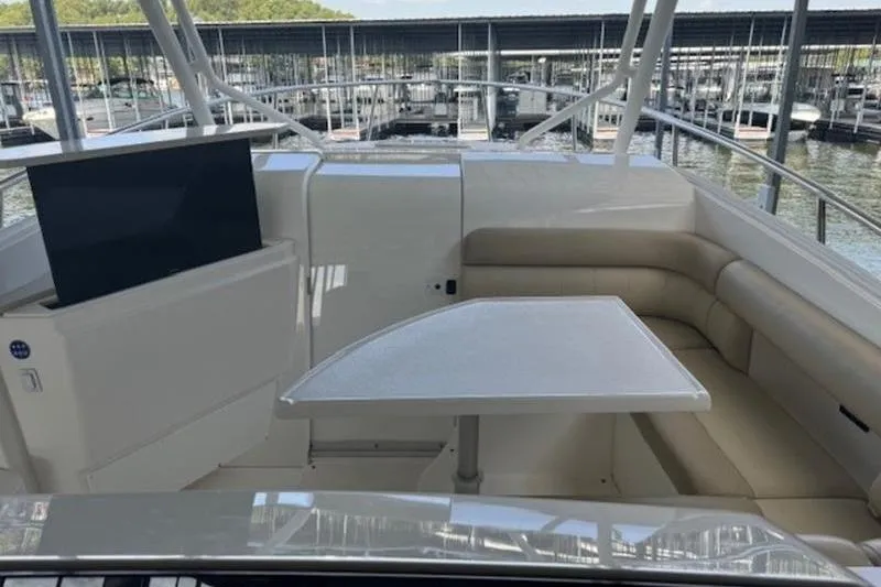 Slide: The Image of 2016 Everglades 360LXC boat interior with seating and table, docked at marina. - 45