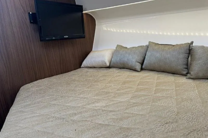 Slide: The Image of Cozy cabin interior of 2016 Everglades 360LXC with bed, pillows, and wall-mounted TV. - 46