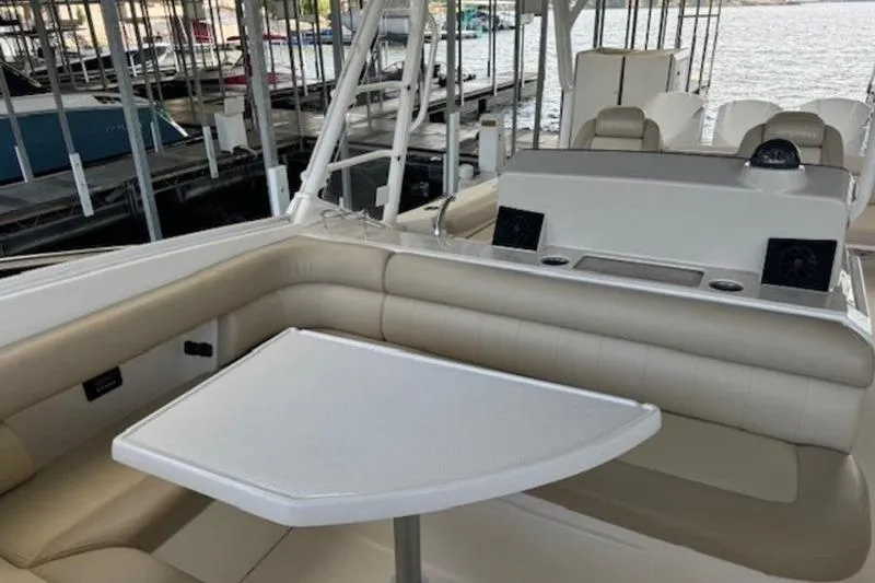 Slide: The Image of 2016 Everglades 360LXC boat interior with seating and table, docked at marina. - 52