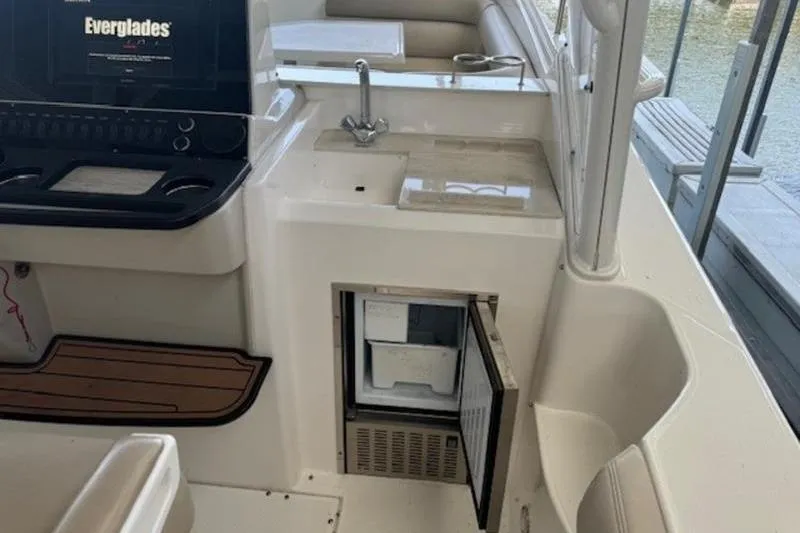 Slide: The Image of 2016 Everglades 360LXC boat interior with sink and open mini-fridge. - 53