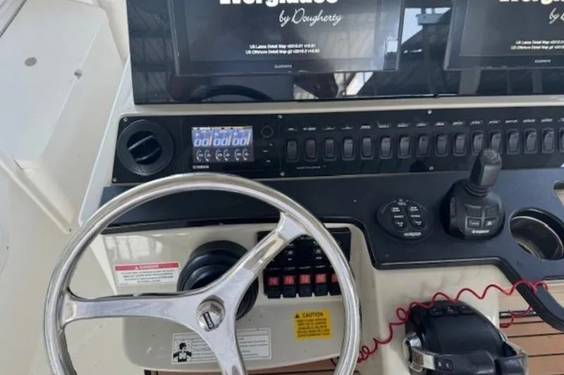Slide: The Image of Control panel of a 2016 Everglades 360LXC boat with steering wheel and navigation screens. - 57
