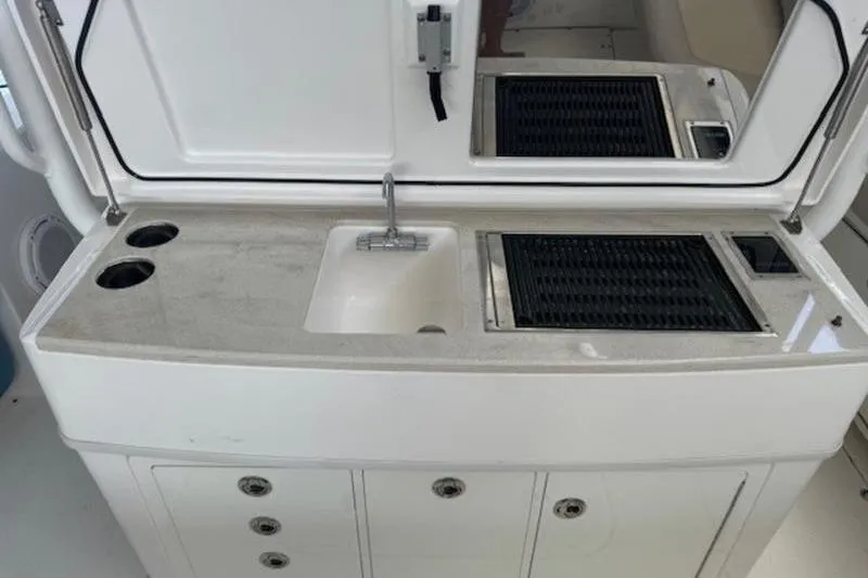 Slide: The Image of 2016 Everglades 360LXC boat kitchenette with sink, grill, and storage compartments. - 6