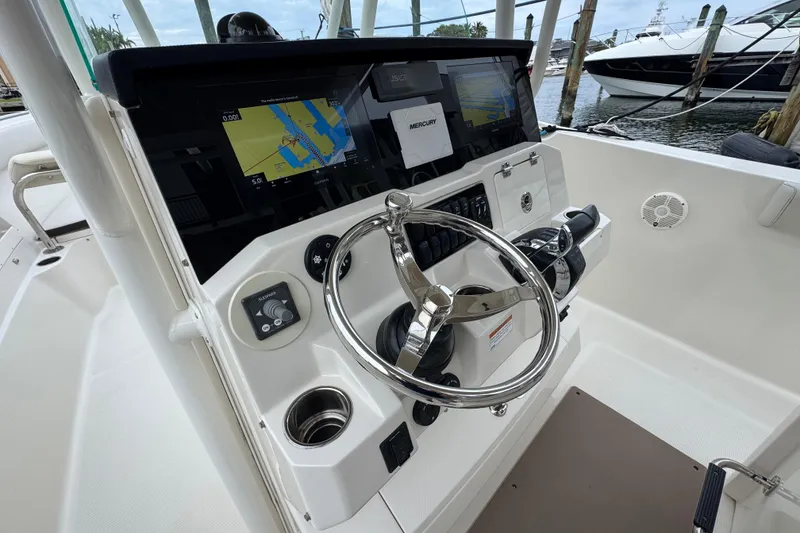 Slide: The Image of 2022 Sailfish 320 CC boat cockpit with steering wheel and navigation screens. - 10