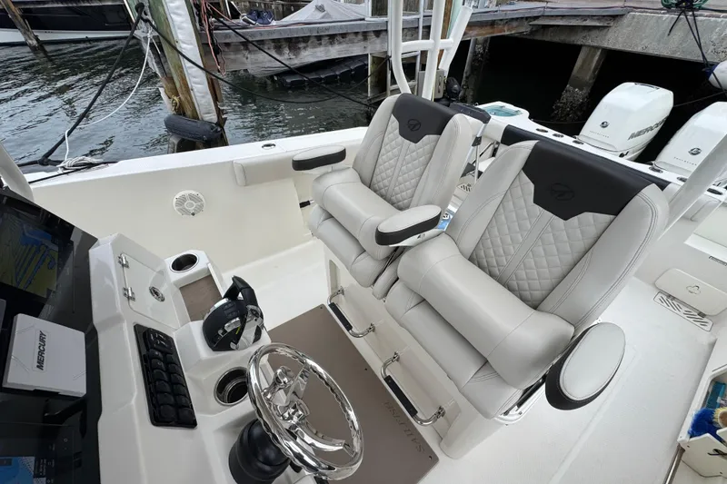 Slide: The Image of 2022 Sailfish 320 CC boat interior with dual captain's chairs and steering console. - 12