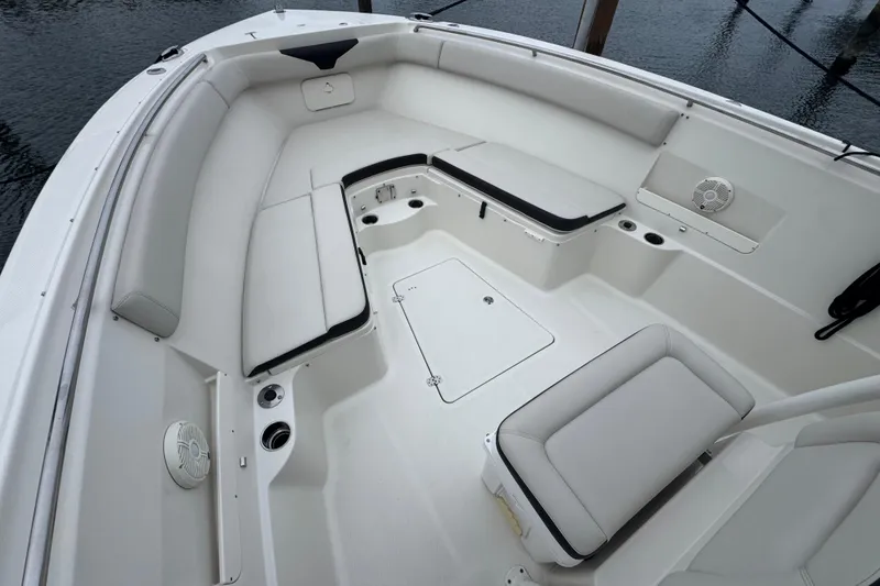 Slide: The Image of 2022 Sailfish 320 CC boat interior with white seating and storage compartments. - 17