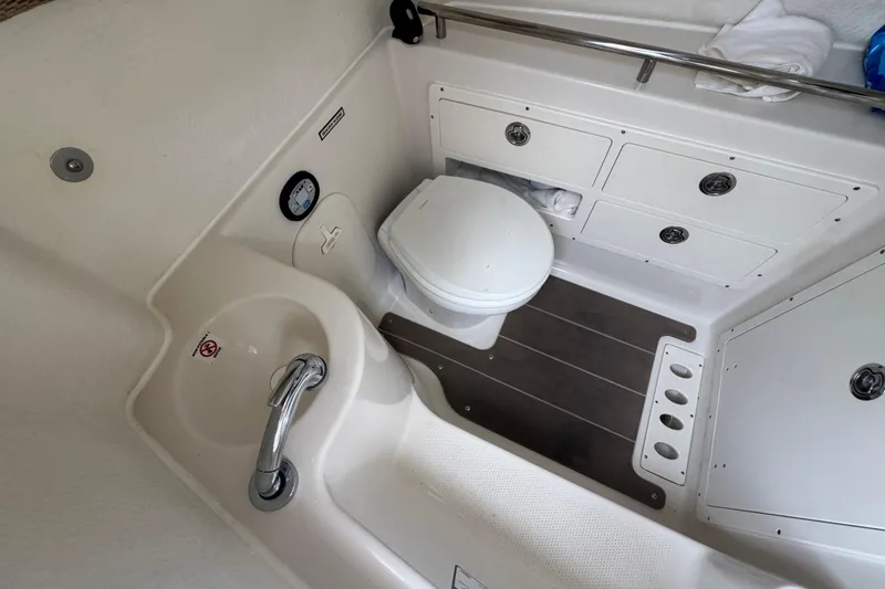 Slide: The Image of 2022 Sailfish 320 CC boat bathroom with sink, toilet, and storage cabinets. - 19