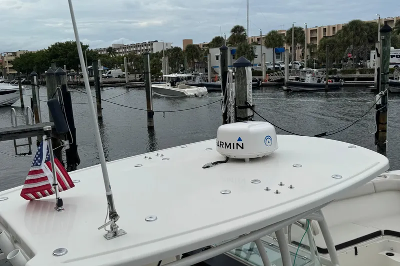Slide: The Image of 2022 Sailfish 320 CC boat docked, featuring Garmin equipment and an American flag. - 20