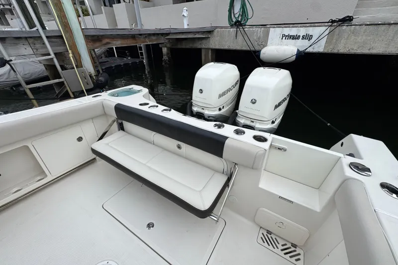 Slide: The Image of 2022 Sailfish 320 CC boat interior with seating and dual Mercury engines at private slip. - 5