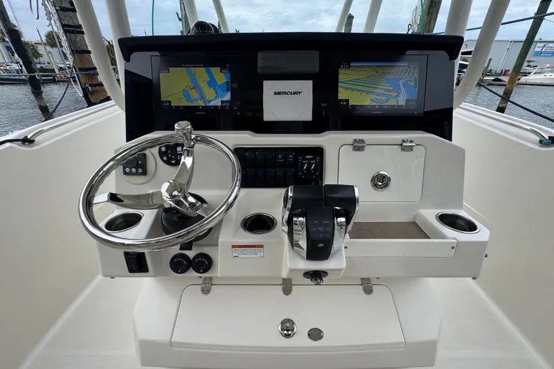 Slide: The Image of 2022 Sailfish 320 CC boat dashboard with steering wheel and navigation screens. - 9
