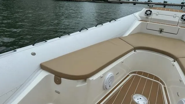 Slide: The Image of 2017 Nuova Jolly Princess boat interior with tan seating and wood accents on water. - 10