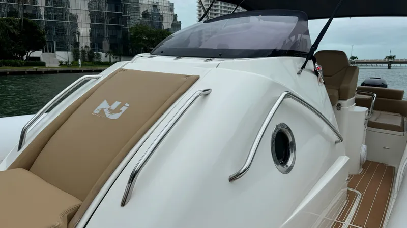 Slide: The Image of 2017 Nuova Jolly Princess boat with sleek design and tan seating, docked near modern buildings. - 24