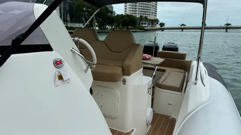 Slide: The Image of 2017 Nuova Jolly Princess boat interior with tan seating, steering wheel, and waterfront view. - 32