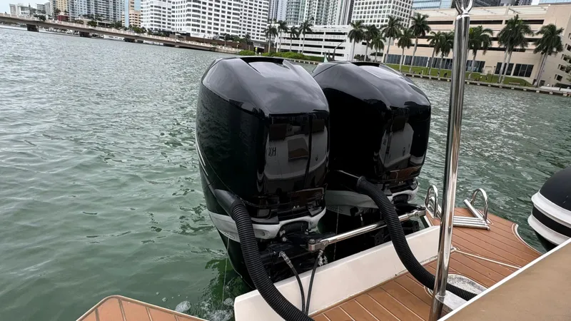 Slide: The Image of Twin outboard motors on a 2017 Nuova Jolly Princess boat, docked in a city marina. - 48