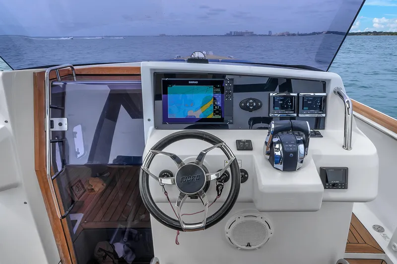Slide: The Image of 2019 Fjord 38 yacht helm with navigation screens and steering wheel, overlooking the ocean. - 12