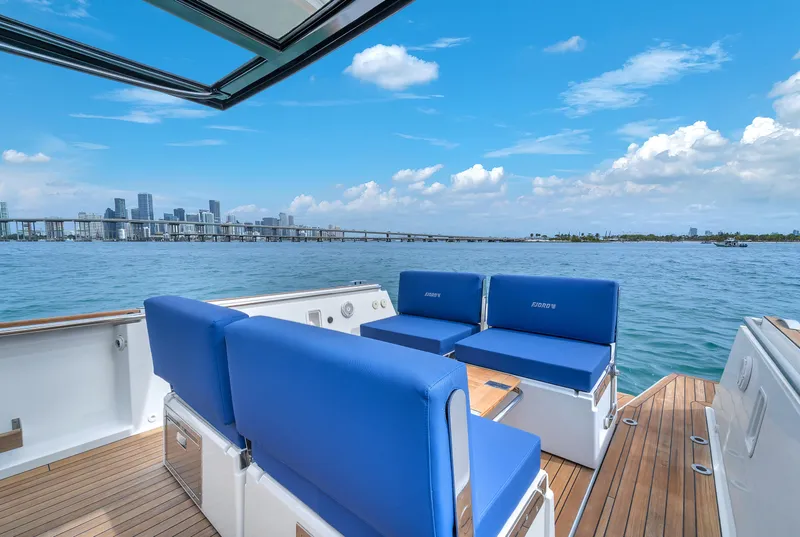 Slide: The Image of Fjord 38 boat with blue seating, city skyline, and clear sky in the background. - 20