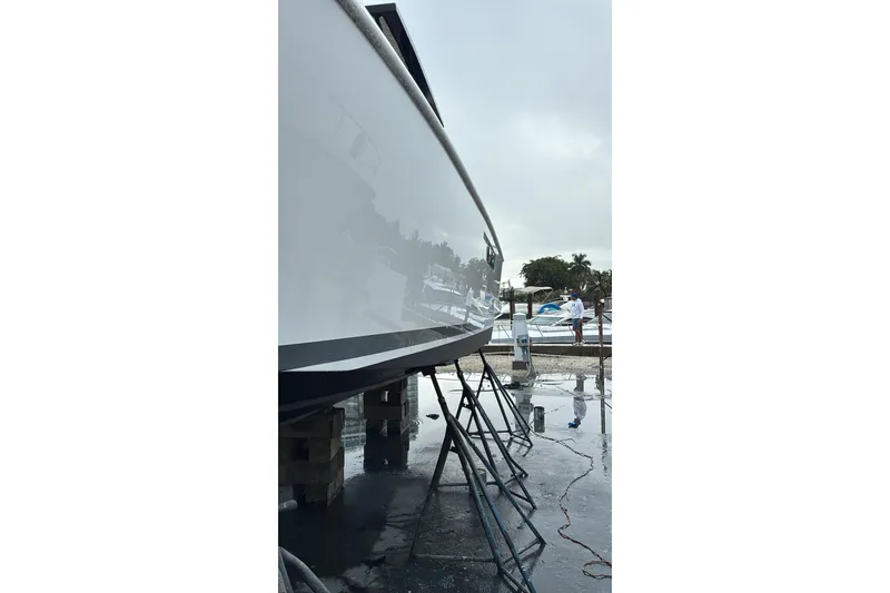 Slide: The Image of 2019 Fjord 38 boat on stands, reflecting surroundings in a marina setting. - 46