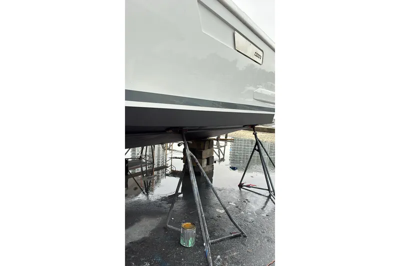 Slide: The Image of 2019 Fjord 38 boat on stands for maintenance, with visible hull and paint supplies. - 48