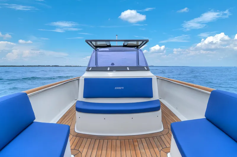 Slide: The Image of Fjord 38 boat, 2019 model, with blue seating and wooden deck on open sea. - 8
