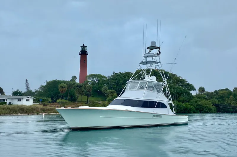 The Image of 1999 Merritt Sportfish yacht near a lighthouse on a calm waterway. - 0