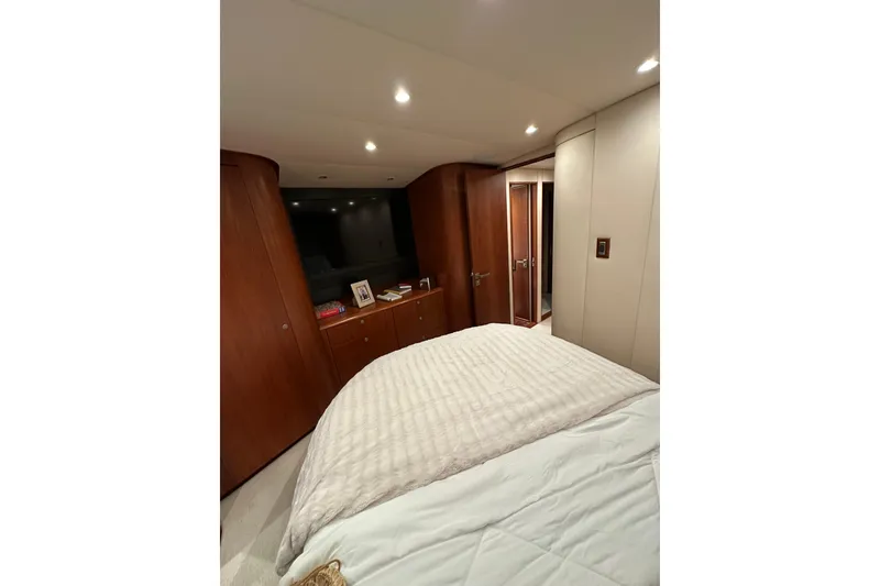 Slide: The Image of Luxurious cabin interior of 1999 Merritt Sportfish yacht with wood accents and cozy bedding. - 11