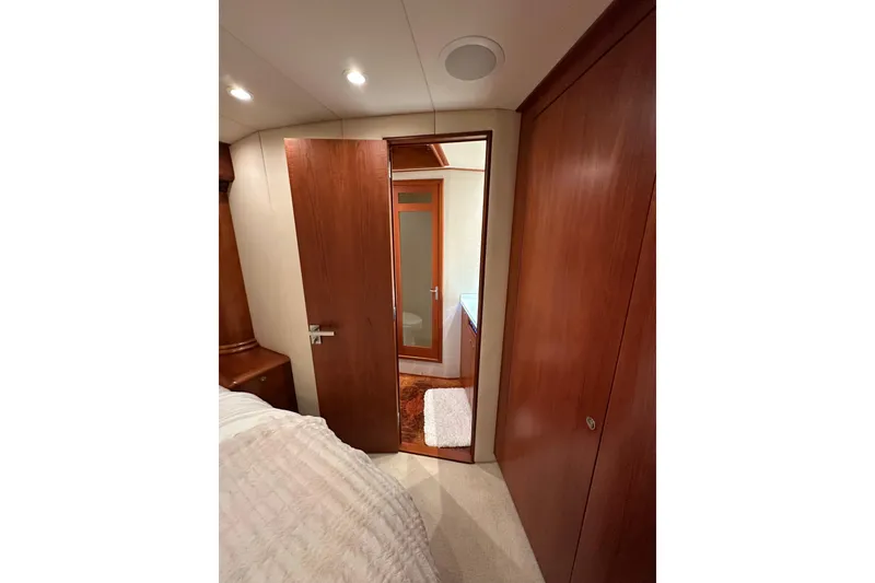 Slide: The Image of Interior of 1999 Merritt Sportfish yacht with wooden doors and cozy bedroom. - 12