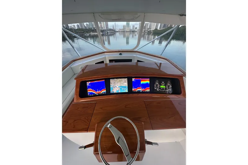 Slide: The Image of 1999 Merritt Sportfish helm with advanced navigation displays and city skyline view. - 15