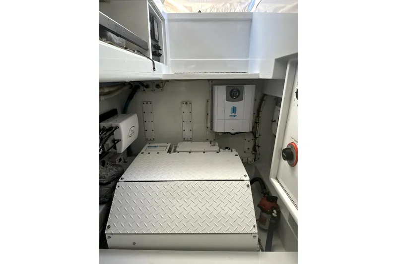 Slide: The Image of Engine room of a 1999 Merritt Sportfish boat, featuring mechanical components and wiring. - 21