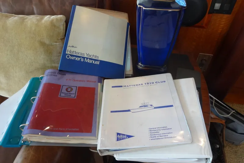 Slide: The Image of Manuals and documents for a 1977 Hatteras 53 Motor Yacht on a table. - 106
