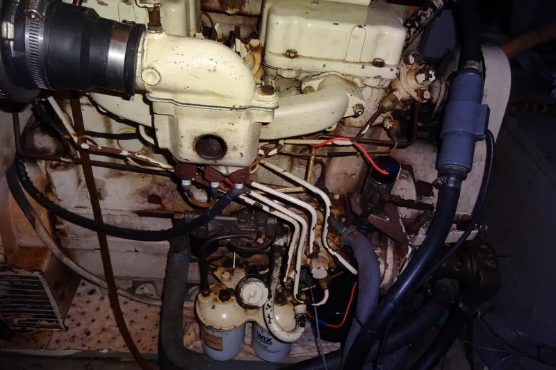 Slide: The Image of Engine compartment of a 1977 Hatteras 53 Motor Yacht, showing mechanical components and hoses. - 123