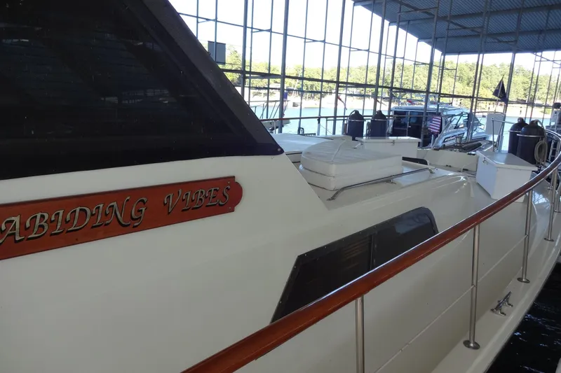 Slide: The Image of 1977 Hatteras 53 Motor Yacht docked in a marina, showcasing sleek design and spacious deck. - 13