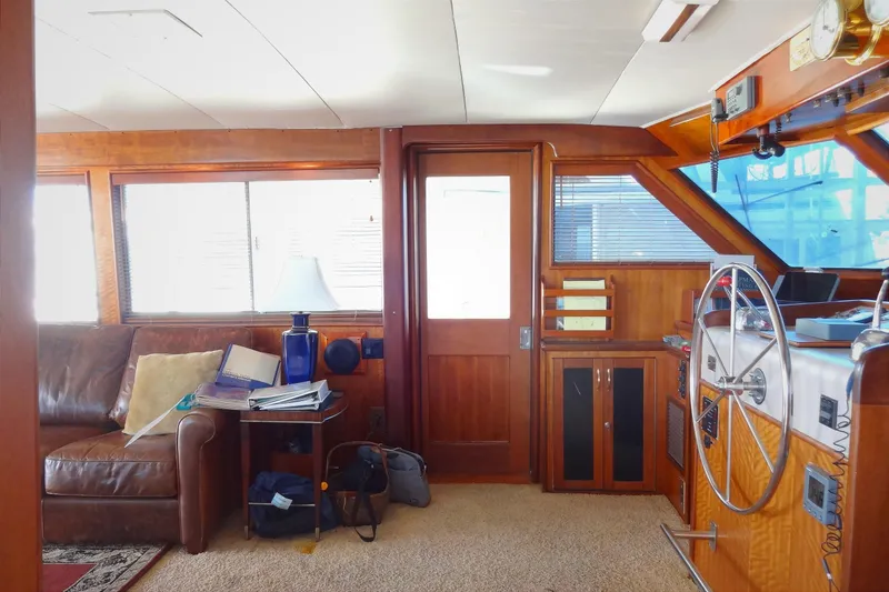 Slide: The Image of Interior of a 1977 Hatteras 53 Motor Yacht with wooden paneling and steering wheel. - 15