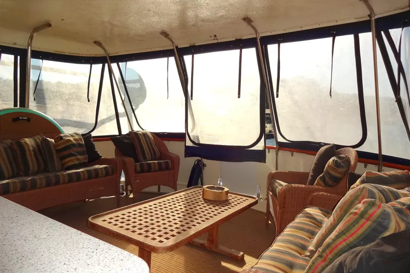 Slide: The Image of 1977 Hatteras 53 Motor Yacht interior with wicker seating and striped cushions. - 23