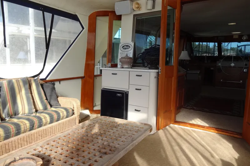 Slide: The Image of Interior of 1977 Hatteras 53 Motor Yacht with wicker seating and wooden accents. - 25