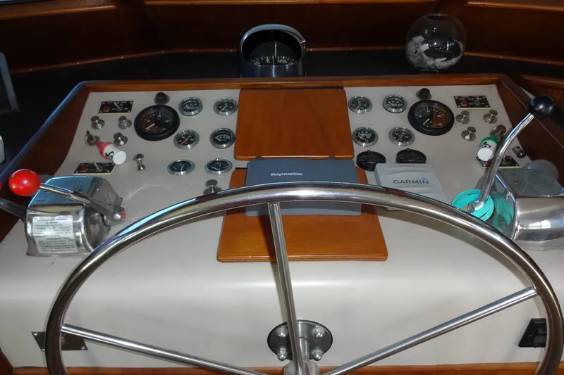 Slide: The Image of 1977 Hatteras 53 Motor Yacht helm with gauges, controls, and steering wheel. - 34