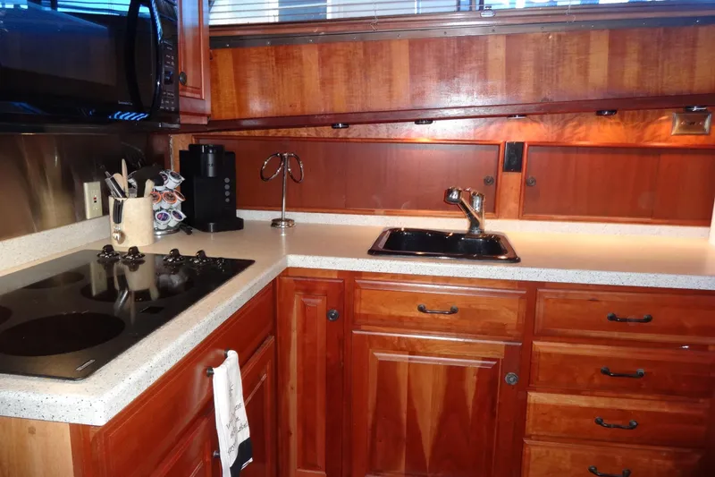 Slide: The Image of 1977 Hatteras 53 Motor Yacht kitchen with wooden cabinets, stove, and sink. - 49