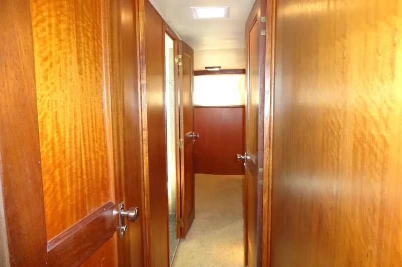 Slide: The Image of Interior hallway of a 1977 Hatteras 53 Motor Yacht with wooden doors and paneling. - 56