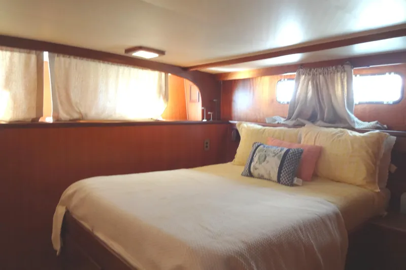 Slide: The Image of Cozy bedroom interior of 1977 Hatteras 53 Motor Yacht with wooden paneling and soft lighting. - 59