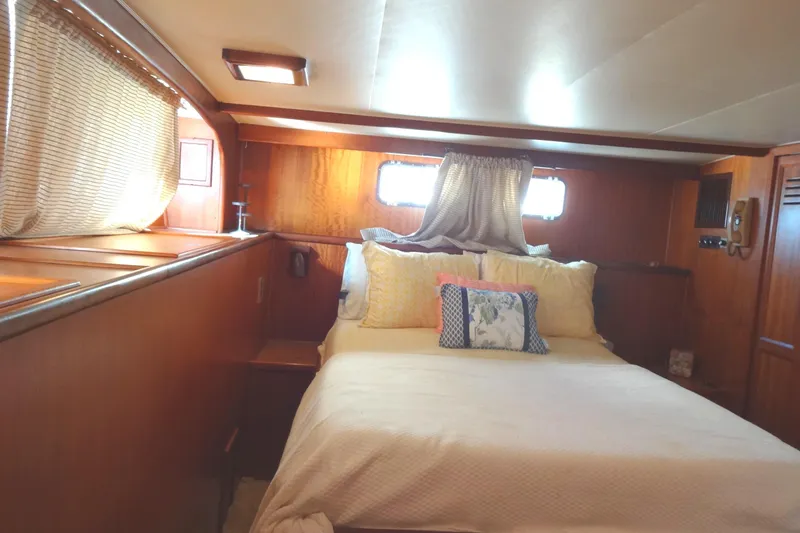 Slide: The Image of Cozy bedroom interior of 1977 Hatteras 53 Motor Yacht with wood paneling and soft lighting. - 60