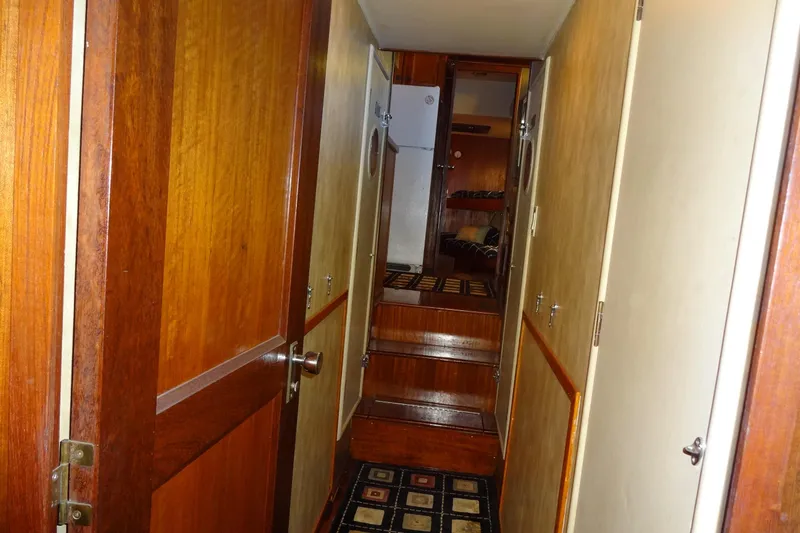 Slide: The Image of Interior hallway of a 1977 Hatteras 53 Motor Yacht with wooden doors and carpeted steps. - 68