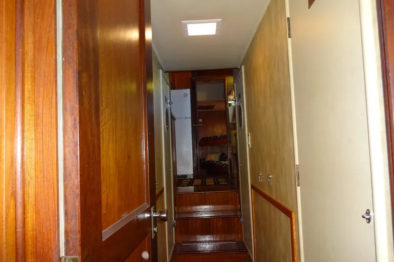 Slide: The Image of Interior hallway of a 1977 Hatteras 53 Motor Yacht with wooden doors and steps. - 70