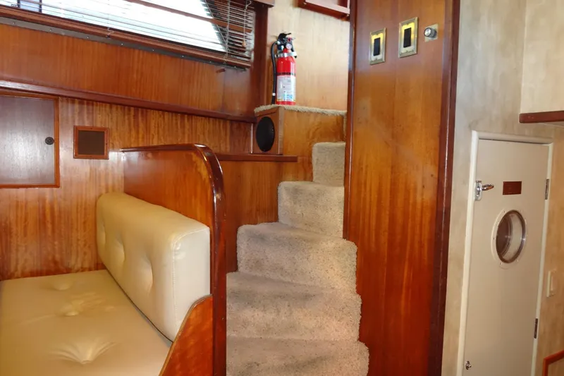 Slide: The Image of Interior of 1977 Hatteras 53 Motor Yacht with wooden paneling and carpeted stairs. - 99